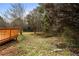 Overgrown backyard featuring trees and vegetation and partially fenced with a wooden deck at 8168 Canyon Forge Dr, Riverdale, GA 30274