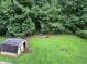Large, green backyard with mature trees and a storage shed at 232 Taylors Farm Dr, Canton, GA 30115