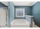 A stylish bathroom with a soaking tub, a separate glass shower, and serene blue walls at 232 Taylors Farm Dr, Canton, GA 30115