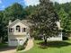 Charming home with a two-car garage and front porch, surrounded by lush greenery and mature landscaping at 232 Taylors Farm Dr, Canton, GA 30115