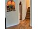 Hallway view leading to kitchen featuring hardwood floors, arched doorway, and stainless steel appliances at 232 Taylors Farm Dr, Canton, GA 30115