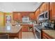 A well-equipped kitchen with warm wood cabinets, granite countertops, and modern stainless steel appliances at 232 Taylors Farm Dr, Canton, GA 30115