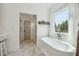 Luxurious bathroom featuring a freestanding soaking tub and marble floors at 3842 Ernest W Barrett Sw Pkwy, Marietta, GA 30064