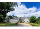 Stunning white farmhouse exterior with a three-car garage and landscaped lawn at 3842 Ernest W Barrett Sw Pkwy, Marietta, GA 30064