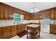 Kitchen features wood cabinets, granite island, and white appliances at 4698 Norman Nw Dr, Kennesaw, GA 30144