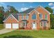 Brick two-story house with a two-car garage and landscaped lawn at 93 Carriage Lake Dr, Stockbridge, GA 30281