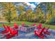 Outdoor fire pit surrounded by red Adirondack chairs in a grassy backyard at 1445 Hillside Dr, Grayson, GA 30017