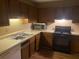 Kitchen features wood cabinets, a double sink, and black appliances at 1753 Ridge Se Ct, Conyers, GA 30013