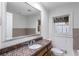 Bathroom featuring granite countertops, cherry wood cabinetry, and tile backsplash at 2468 Ridgeway Dr, Atlanta, GA 30360