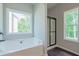 Bright bathroom with a soaking tub under a large window and glass enclosed shower at 459 Benson Meadows Dr, Dallas, GA 30157