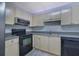 Well-lit kitchen with black appliances and tiled backsplash at 533 Bentley Pl, Tucker, GA 30084