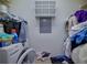 A cluttered laundry room with a white washer and dryer featuring disorganized supplies and clothes around the appliances at 533 Bentley Pl, Tucker, GA 30084