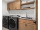 Functional laundry room with modern appliances and wood cabinets at 200 Simonton Rd, Lawrenceville, GA 30046