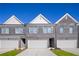 Three-unit townhome building with gray brick exterior and attached garages at 233 Epping Street # 90, Stockbridge, GA 30281