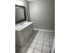 Well-lit bathroom with a single sink vanity, a black framed mirror, and tile flooring at 6494 Pleasant Dr, Winston, GA 30187