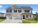 Two-story house with gray stone and white accents, two-car garage, and landscaped lawn at 3238 Champions Way, Loganville, GA 30052