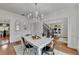 Bright dining room features hardwood floors, chandelier, and white table with metal chairs at 3350 Vista Creek Dr, Dacula, GA 30019