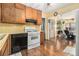 Kitchen with wood cabinets, white appliances and access to backyard at 1980 Campfire Dr, Riverdale, GA 30296