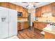 Kitchen with wood cabinets, white appliances, and hardwood floors at 1980 Campfire Dr, Riverdale, GA 30296