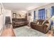 Living room with hardwood floors, brown sofas, and a view of the staircase at 1980 Campfire Dr, Riverdale, GA 30296