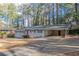 View of the home's front exterior featuring a long driveway, a well-maintained lawn, and a carport at 3482 Scenic Dr, Atlanta, GA 30344