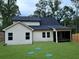 Backyard featuring a freshly-mowed lawn, dark roof, light siding, and a screened porch at 485 N Oakland Cir, Mcdonough, GA 30253