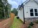 Home exterior view of fenced yard, stone foundation, and light vinyl siding at 485 N Oakland Cir, Mcdonough, GA 30253