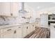 Newly remodeled kitchen with marbled backsplash, countertops, and sleek stainless steel hood at 485 N Oakland Cir, Mcdonough, GA 30253