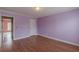 Simple bedroom with lavender walls and hardwood floors at 601 Rangeley Meadows Ct, Hampton, GA 30228