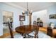 Spacious dining room with hardwood floors, a view into the kitchen, and an elegant chandelier at 1440 Vinery Ave, Cumming, GA 30041