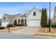 Two-story house with white siding, two-car garage, and landscaping at 1440 Vinery Ave, Cumming, GA 30041