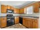 Kitchen with wood cabinets, black appliances, and tile floor at 3335 Pinta Way, Douglasville, GA 30135