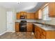 Kitchen with wood cabinets, black appliances, and tile floor at 3335 Pinta Way, Douglasville, GA 30135