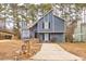 Gray house with stone accents and a paved driveway, nestled among trees at 6300 Creekford Dr, Lithonia, GA 30058