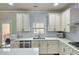 Modern kitchen with white cabinets, stainless steel appliances, and a corner sink at 1265 Gallatin Way, Suwanee, GA 30024