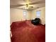 Spacious bedroom with red carpet, ceiling fan, and recliner at 2675 Flat Shoals Rd, Decatur, GA 30034