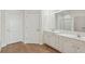 Bathroom with double vanity, large mirror and neutral tile floors at 2614 Grapevine Cir, Cumming, GA 30041