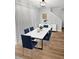 Dining room with white table, blue upholstered chairs, and a modern light fixture at 268 Springbottom Dr, Lawrenceville, GA 30046