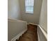 A staircase with a wooden floor and a window on the upper landing at 268 Springbottom Dr, Lawrenceville, GA 30046