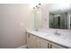 Elegant bathroom with double sinks, modern lighting, and a glass-enclosed shower with tiled walls at 3002 Laguna Dr, Decatur, GA 30032