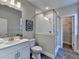 Modern bathroom with white vanity, glass shower, and gray tile floors at 606 Broadview Ne Ter, Atlanta, GA 30324