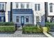 Townhome entrance with a gray brick facade, black metal gate, and manicured landscaping at 606 Broadview Ne Ter, Atlanta, GA 30324