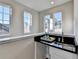 Modern wet bar with black countertop and multiple windows at 606 Broadview Ne Ter, Atlanta, GA 30324