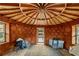 Interior of round room, wood ceiling, cob walls, and access to deck at 157 Timberlost Trl, Suwanee, GA 30024