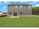 View of home's back elevation, showcasing a patio and grassy yard at 1601 Fuma Leaf Way, Mcdonough, GA 30253