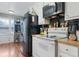 Kitchen with white cabinets, black appliances, and wood flooring at 400 Fleeta Dr, Covington, GA 30016