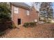 Brick home exterior with a door leading to the backyard with a grassy area covered with leaves at 8240 Knollbrook Ln, Mcdonough, GA 30253