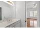 Bright bathroom with white cabinets, a large mirror and a connecting doorway into a bedroom at 8240 Knollbrook Ln, Mcdonough, GA 30253