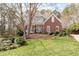 Gorgeous two-story home with brick and stucco exterior, manicured front lawn, and mature trees, creating a picturesque curb appeal at 8240 Knollbrook Ln, Mcdonough, GA 30253