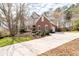 Lovely home featuring a well-manicured lawn, mature trees, long driveway, and a combination of brick and stucco architecture at 8240 Knollbrook Ln, Mcdonough, GA 30253